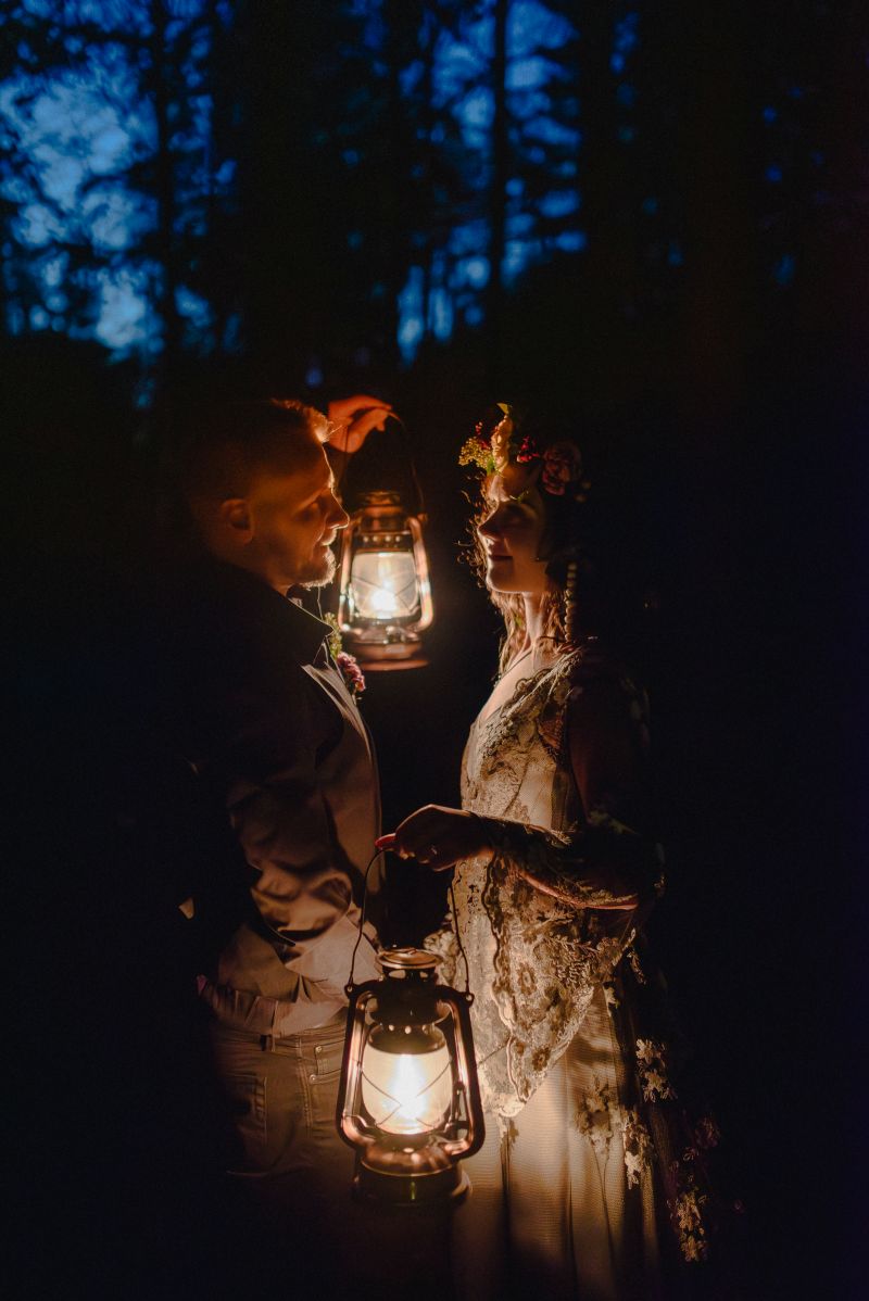 pariskunta lyhdynvalossa metsss